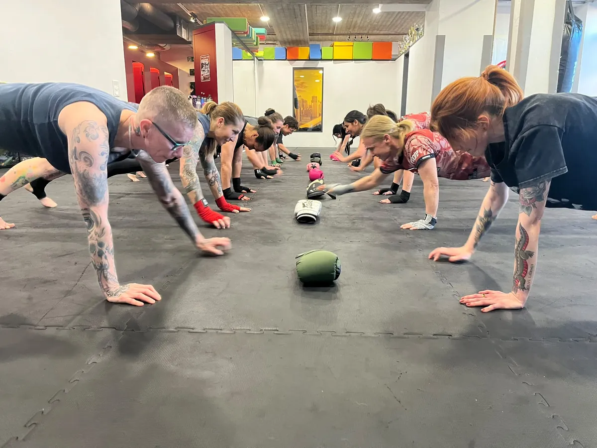 Gruppe hält gemeinsam die Plank-Position beim Zirkeltraining